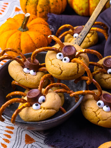 Spider Cookies in a ladle with pumpkins.