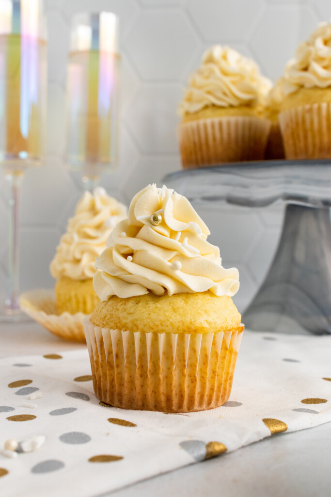 Champagne Cupcakes on polka-dot paper and on a cake stand.