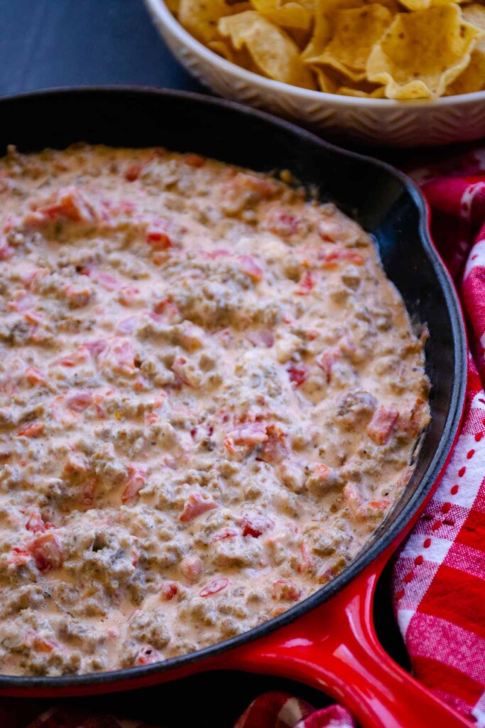 Cream cheese sausage dip in a red cast iron skillet.