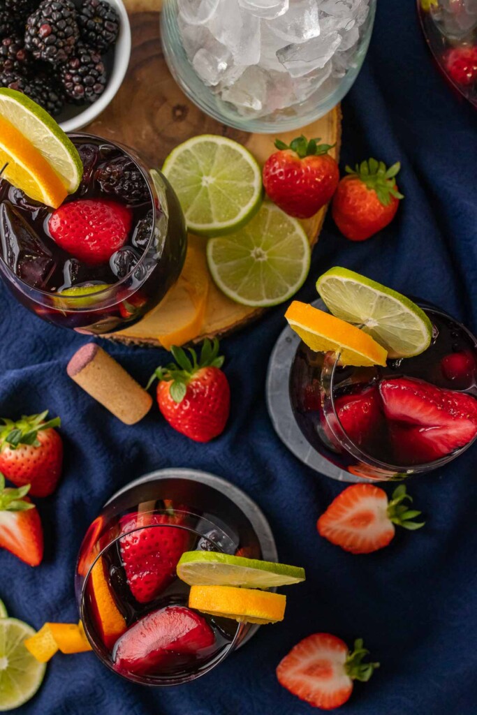 3 glasses of red wine sangria with strawberries and citrus.
