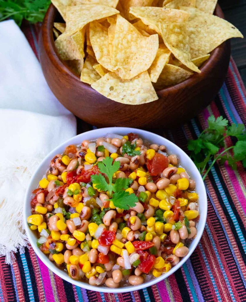 Cowboy Caviar made with black eyed peas, corn, rotel tomatoes and chilies is a great appetizer to serve with chips.
