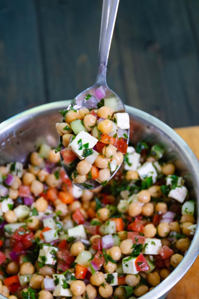 Mediterranean Chickpea Salad served on a spoon for picnics, cookouts and summer gatherings.