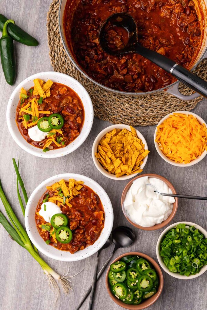 Easy recipe for Beef Chili made with beans, bacon and peppers is a great dish for any party or family meal served with cheese, corn chips and sour cream.